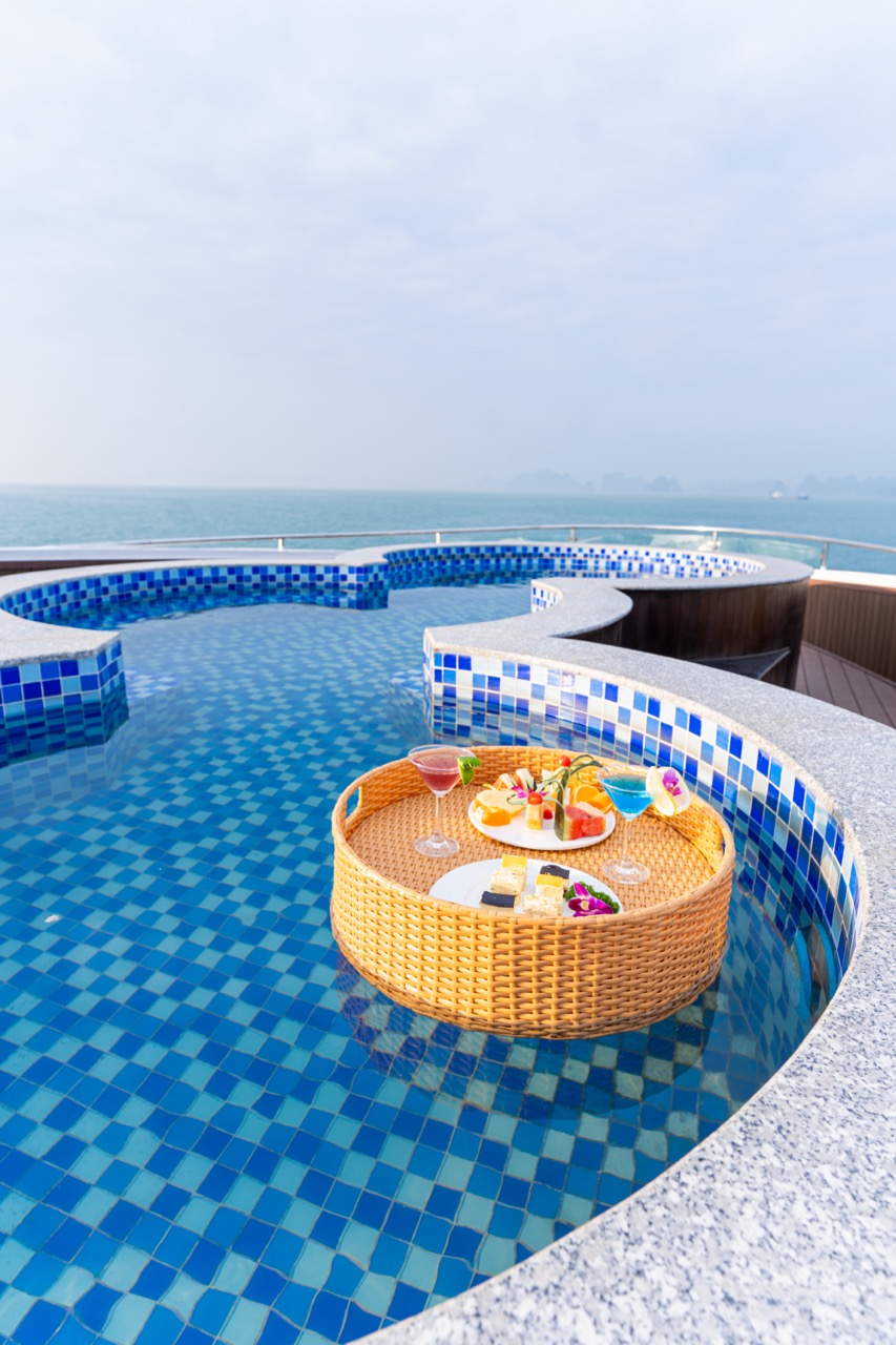 Stunning view of Halong Bay from a luxury cruise balcony with vibrant blue waters and scenic islands.