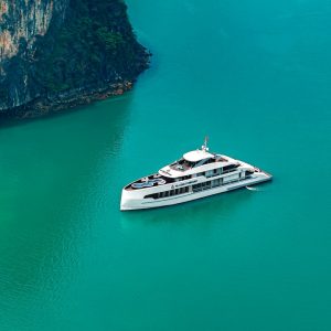See the sleek white yacht framed by towering cliffs and endless turquoise.