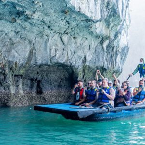 Local rowers guide guests beneath dramatic cliffs where light meets turquoise.