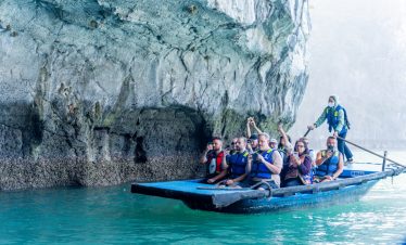 People kayaking near limestone cliffs in Halong Bay, scenic and tranquil.
