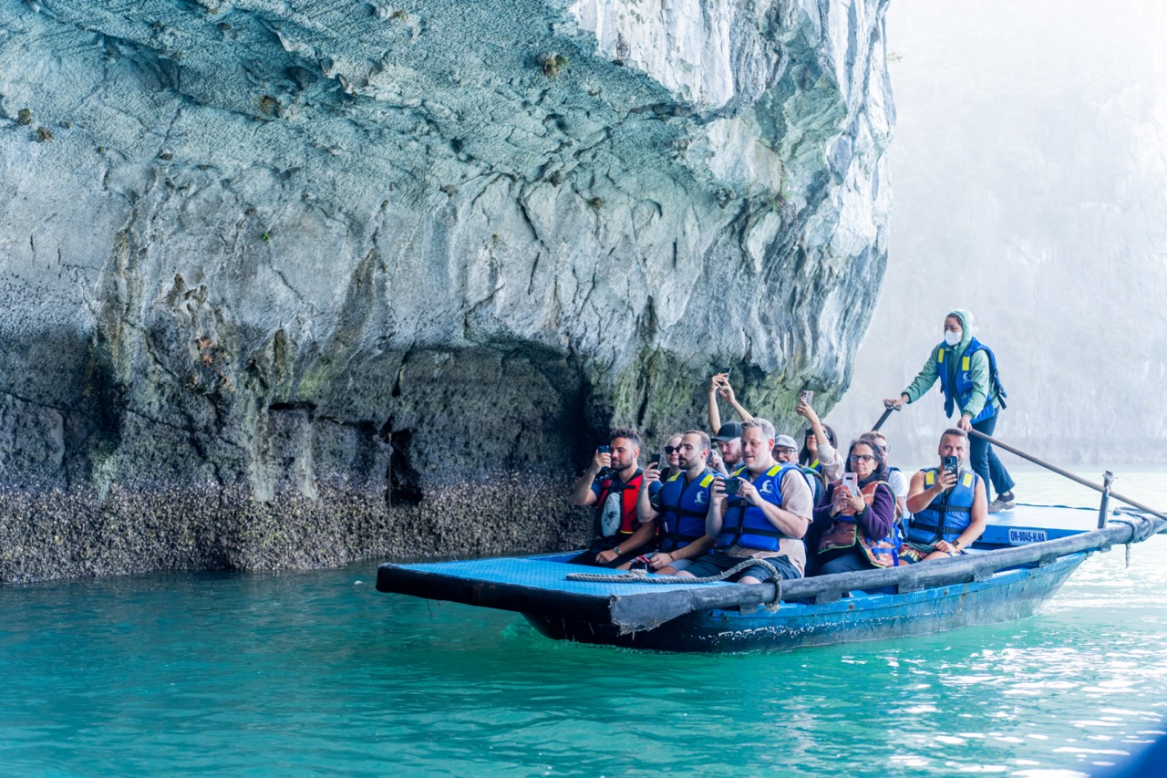 People kayaking near limestone cliffs in Halong Bay, scenic and tranquil.