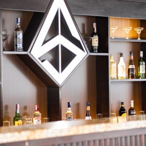 Golden bottles, warm lights, and a friendly bartender ready with your pick.