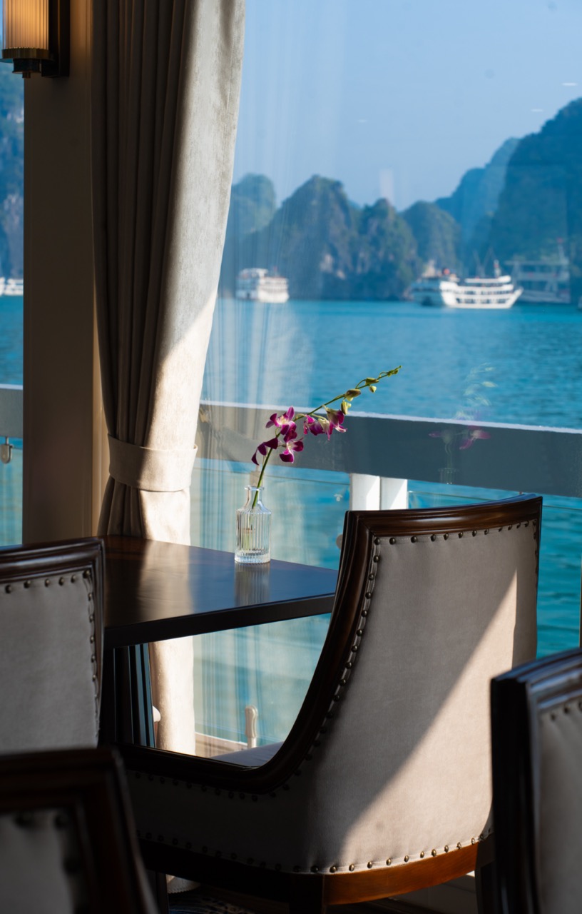 Stunning view of Halong Bay from cruise balcony with calm waters and limestone karsts.