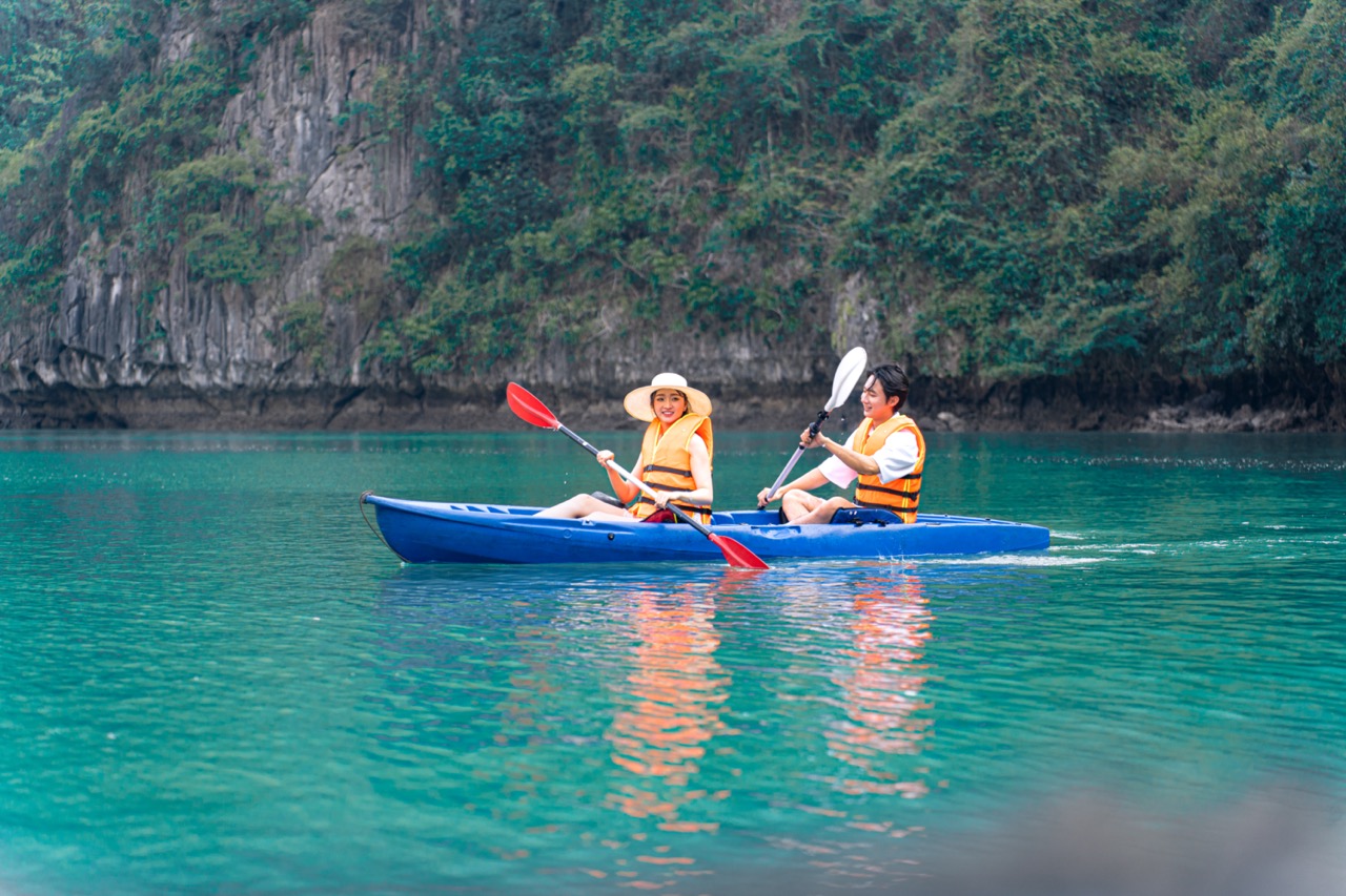 Kayaking in Halong Bay with scenic limestone cliffs and turquoise waters, perfect for an adventurous.