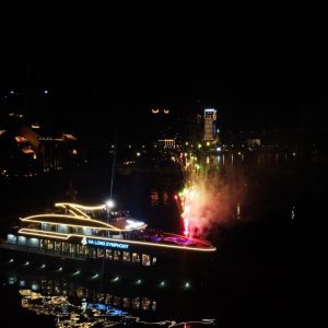 Night lights and fireworks reflect on the water for a show you can feel.