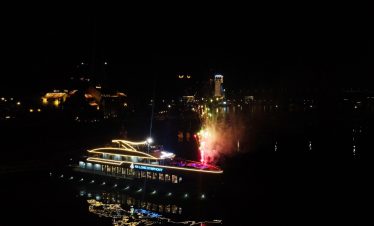 Nighttime Halong Bay cruise with fireworks and illuminated boat scene, perfect for travel enthusiast.