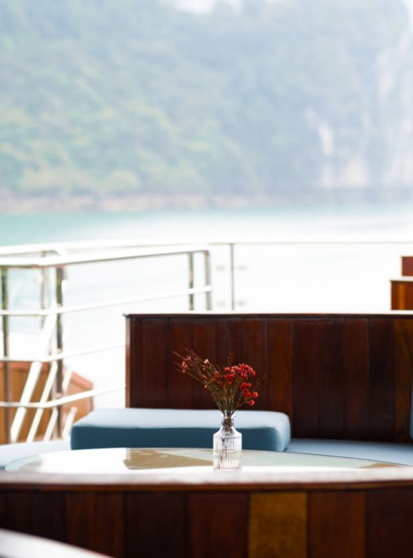 Stunning view from a cruise balcony overlooking Halong Bay's emerald waters and limestone karsts.
