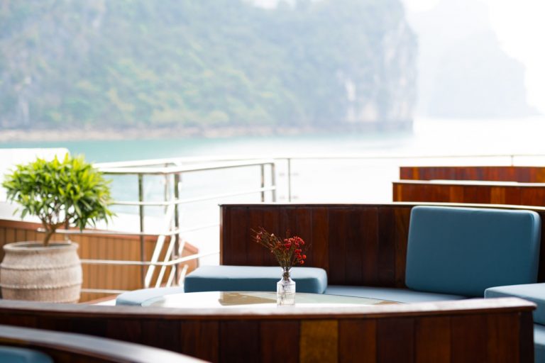 Stunning view from a cruise balcony overlooking Halong Bay's emerald waters and limestone karsts.