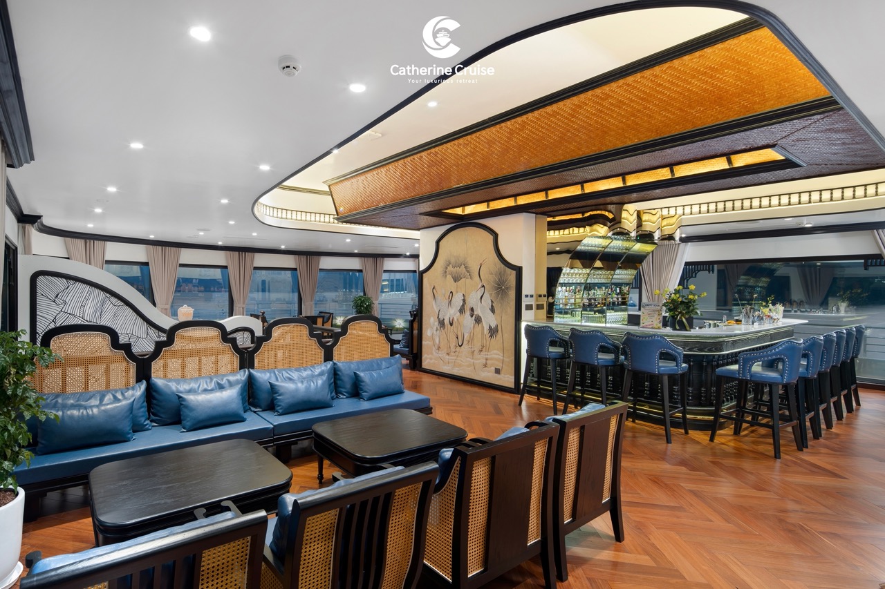 Elegant cruise lounge interior with bar, seating, and panoramic windows.