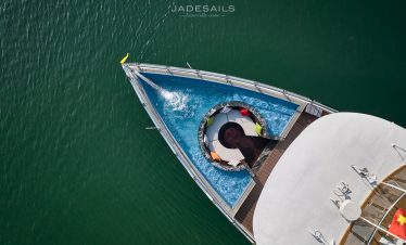 Cruise ship deck with swimming pool and scenic Lan Ha Bay views.