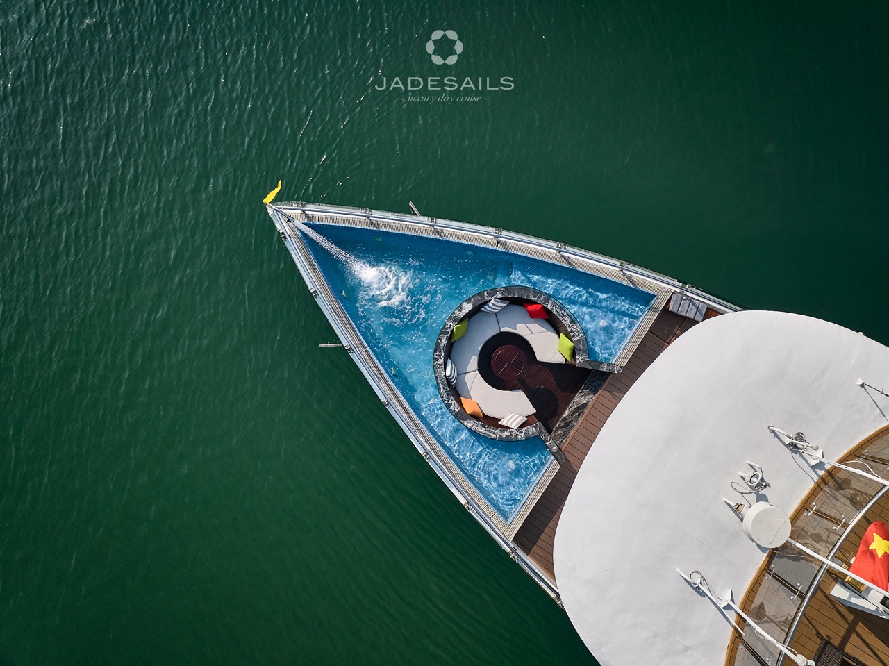 Cruise ship deck with swimming pool and scenic Lan Ha Bay views.