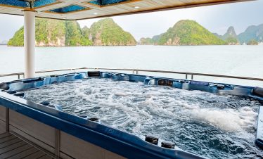 Relaxing hot tub on Halong Bay cruise with scenic limestone islands in the background.