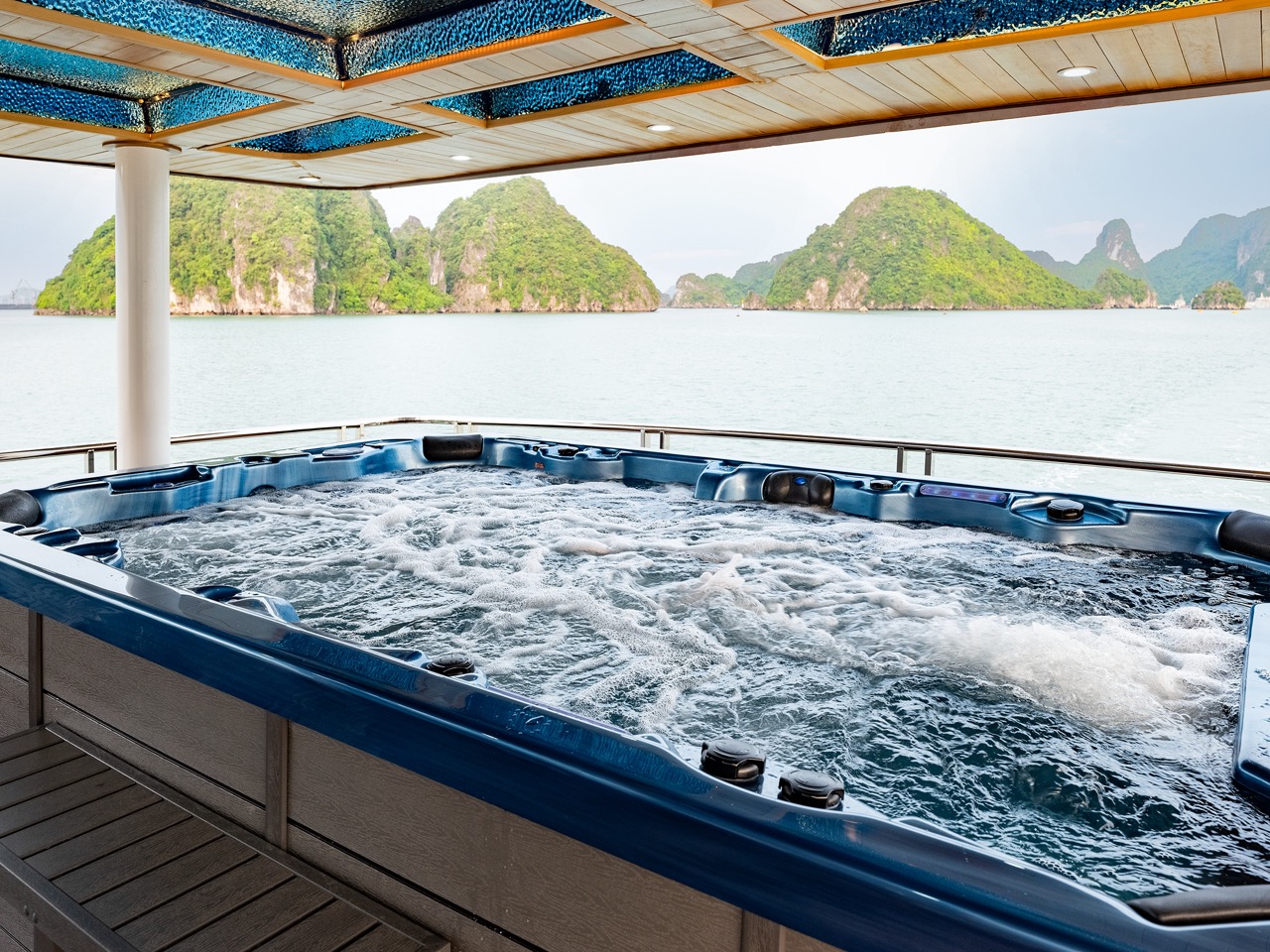 Relaxing hot tub on Halong Bay cruise with scenic limestone islands in the background.