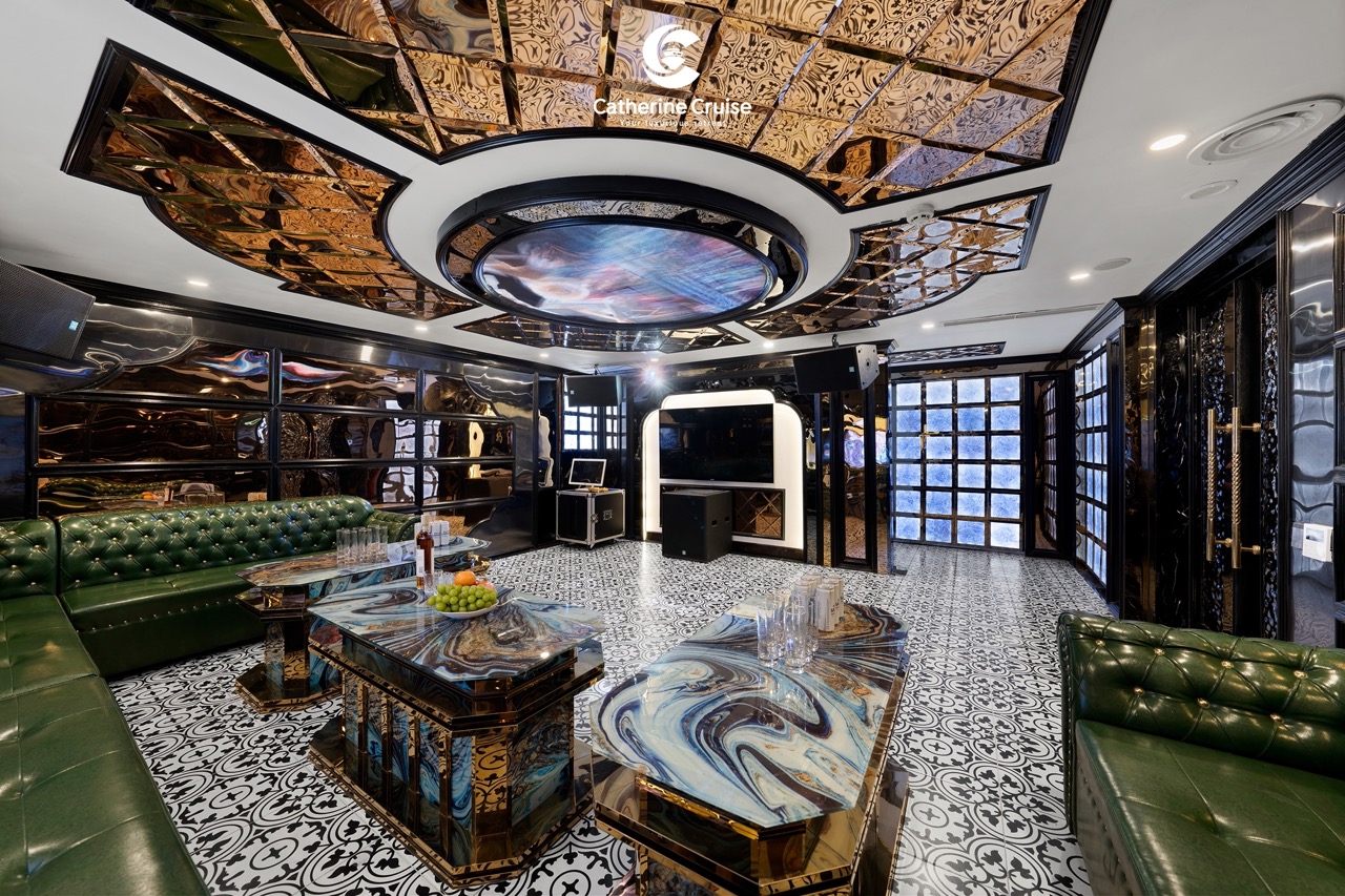 Luxurious cruise lounge with marble tables, green leather seating, and elegant interior design.