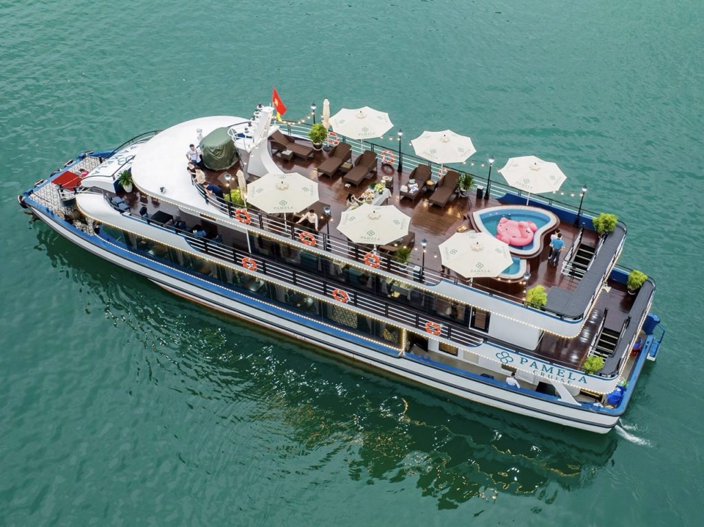 Aerial view of a luxurious Halong Bay cruise ship with rooftop lounge, private deck, and scenic wate.