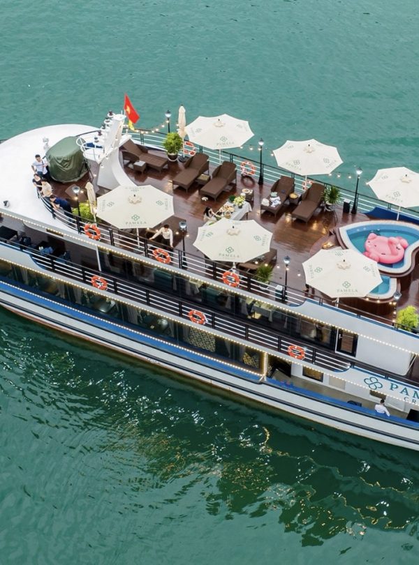 Aerial view of a luxurious Halong Bay cruise ship with rooftop lounge, private deck, and scenic wate.