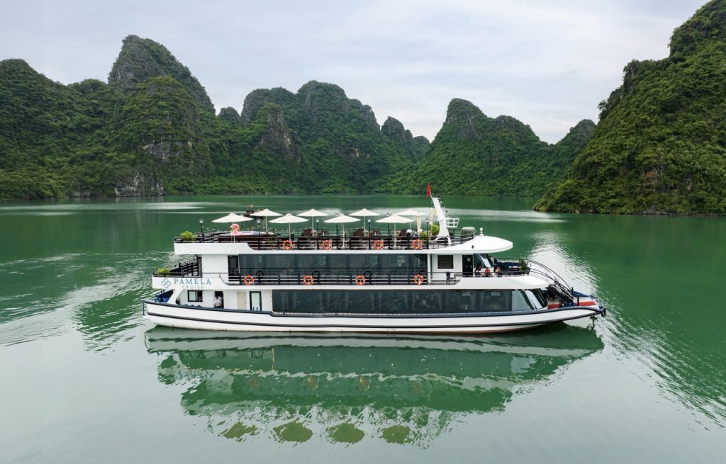 Luxury cruise boat on Halong Bay with stunning limestone karsts.