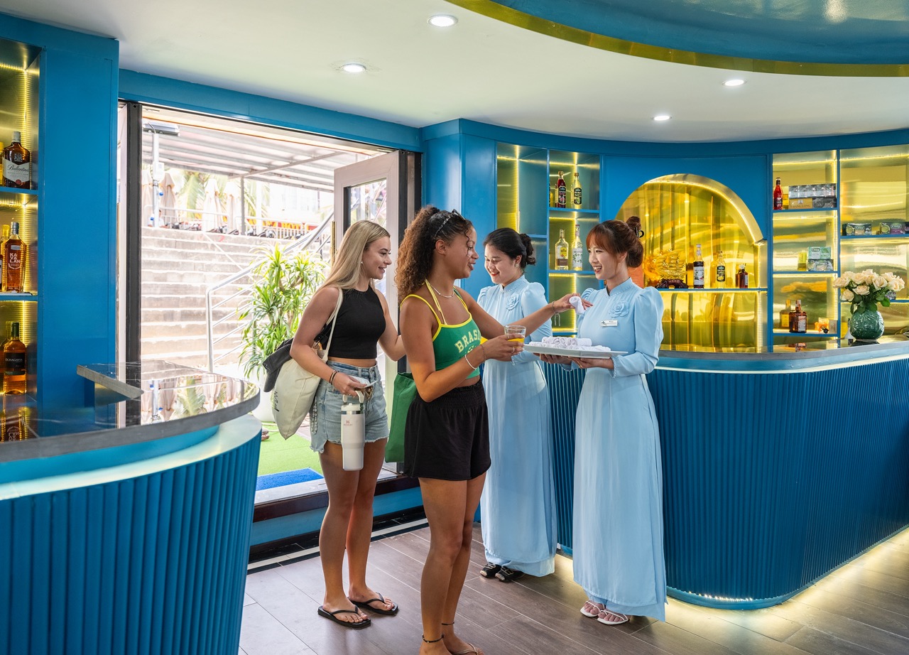 Scenic Halong Bay cruise scene with travelers checking in, vibrant interior, and welcoming staff.