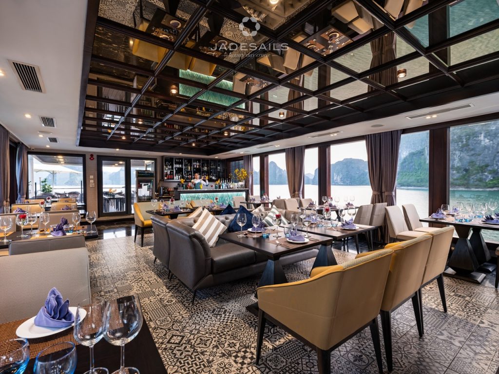 Luxurious cruise lounge with panoramic views of Halong Bay, elegant seating, and stylish decor.