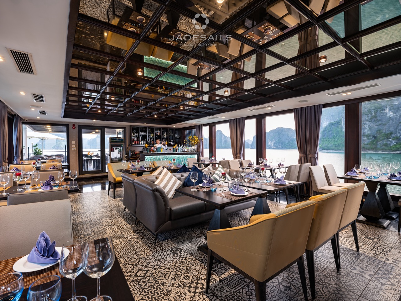 Luxurious cruise lounge with panoramic views of Halong Bay, elegant seating, and stylish decor.