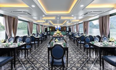 Elegant cruise dining area with panoramic views of Halong Bay, perfect for a luxurious sailing exper.