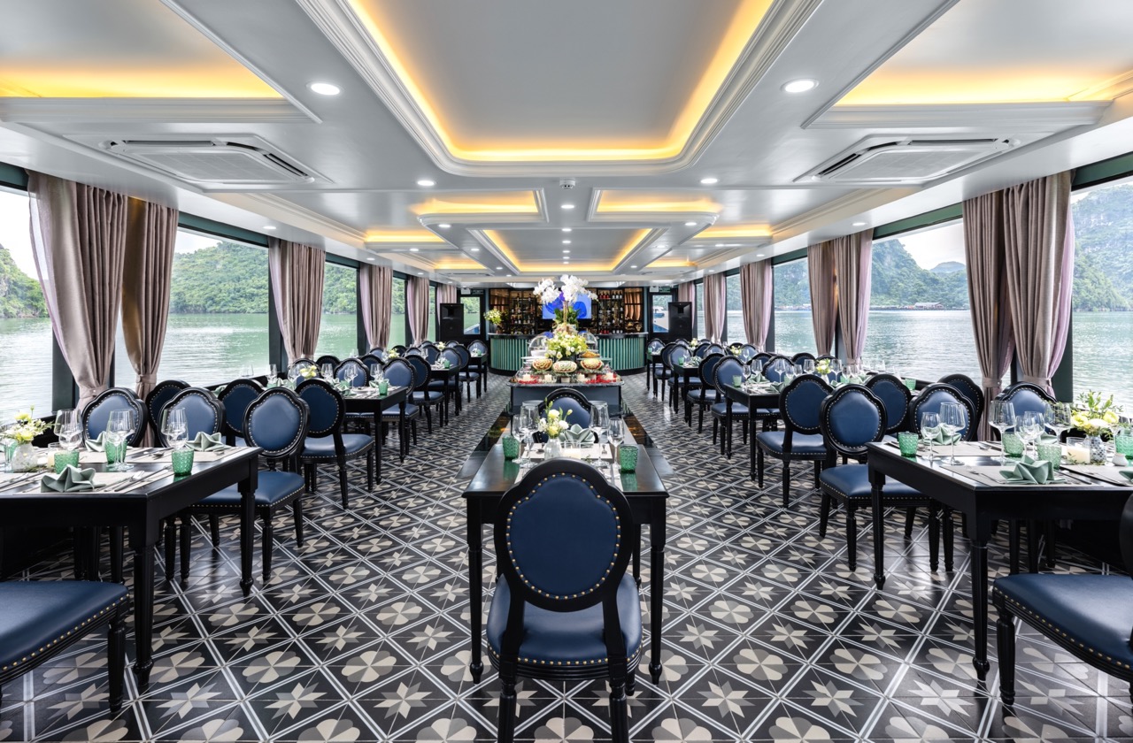 Elegant cruise dining area with panoramic views of Halong Bay, perfect for a luxurious sailing exper.