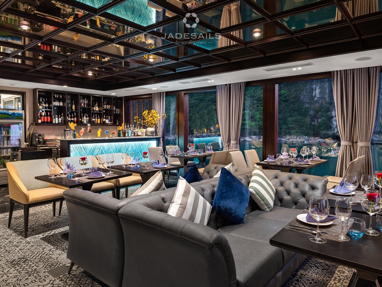 Elegant cruise lounge with panoramic views of Halong Bay, featuring stylish seating and sophisticate.