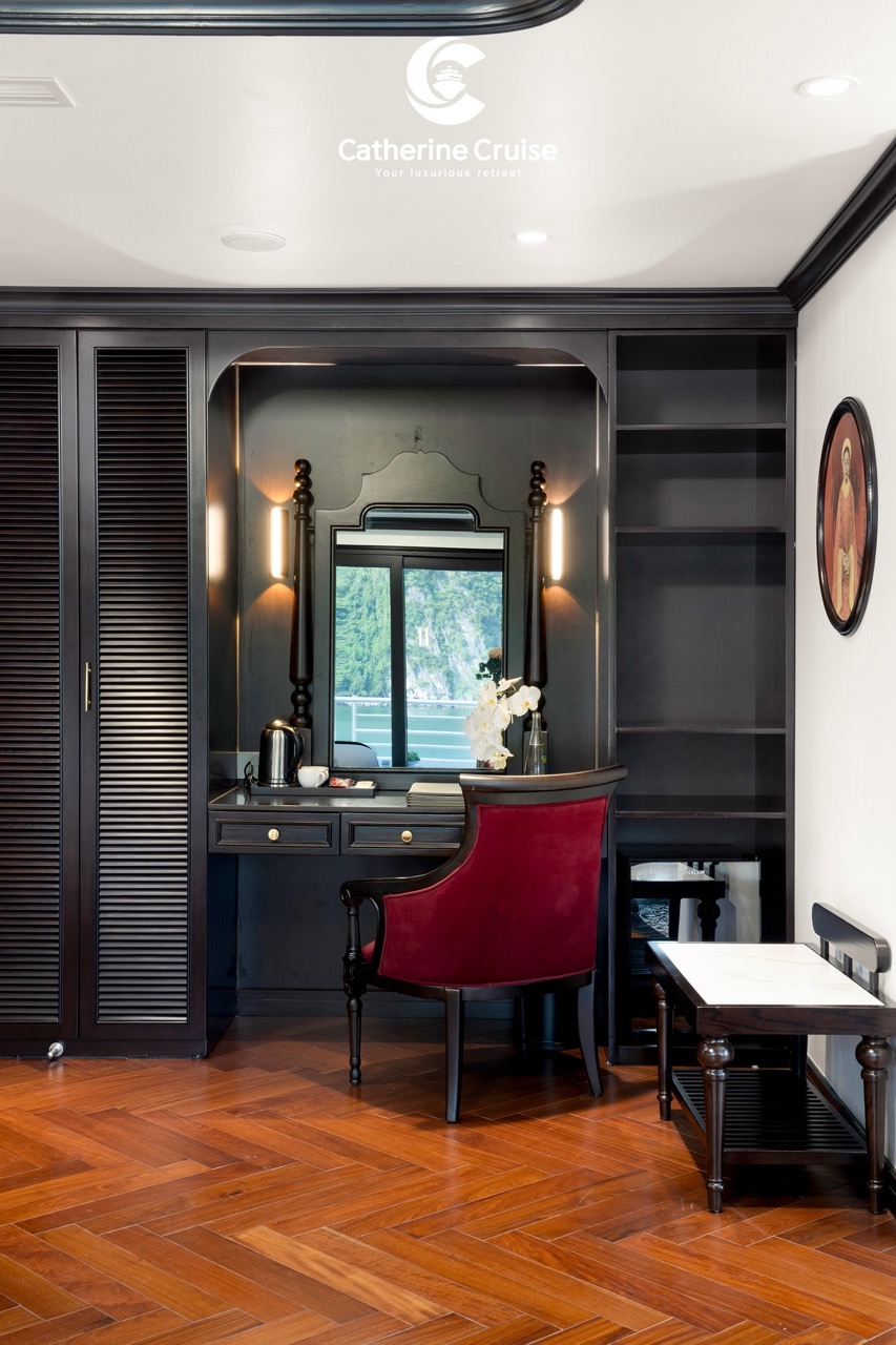 Luxurious hotel room vanity with mirror, red armchair, wooden flooring, and elegant decor.