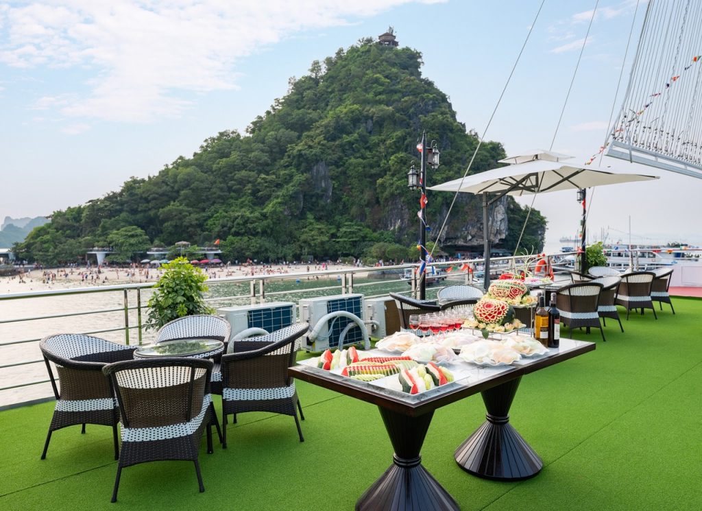 Scenic view of Halong Bay from a cruise balcony with lush green island and calm waters, perfect for.