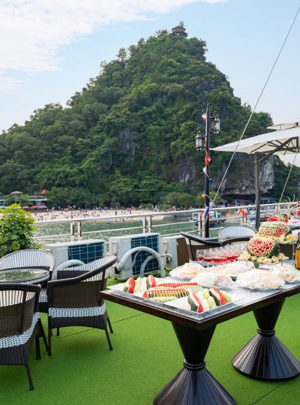 Scenic view of Halong Bay from a cruise balcony with lush green island and calm waters, perfect for.