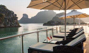 Stunning Halong Bay cruise balcony with scenic limestone karsts and tranquil waters at sunset.