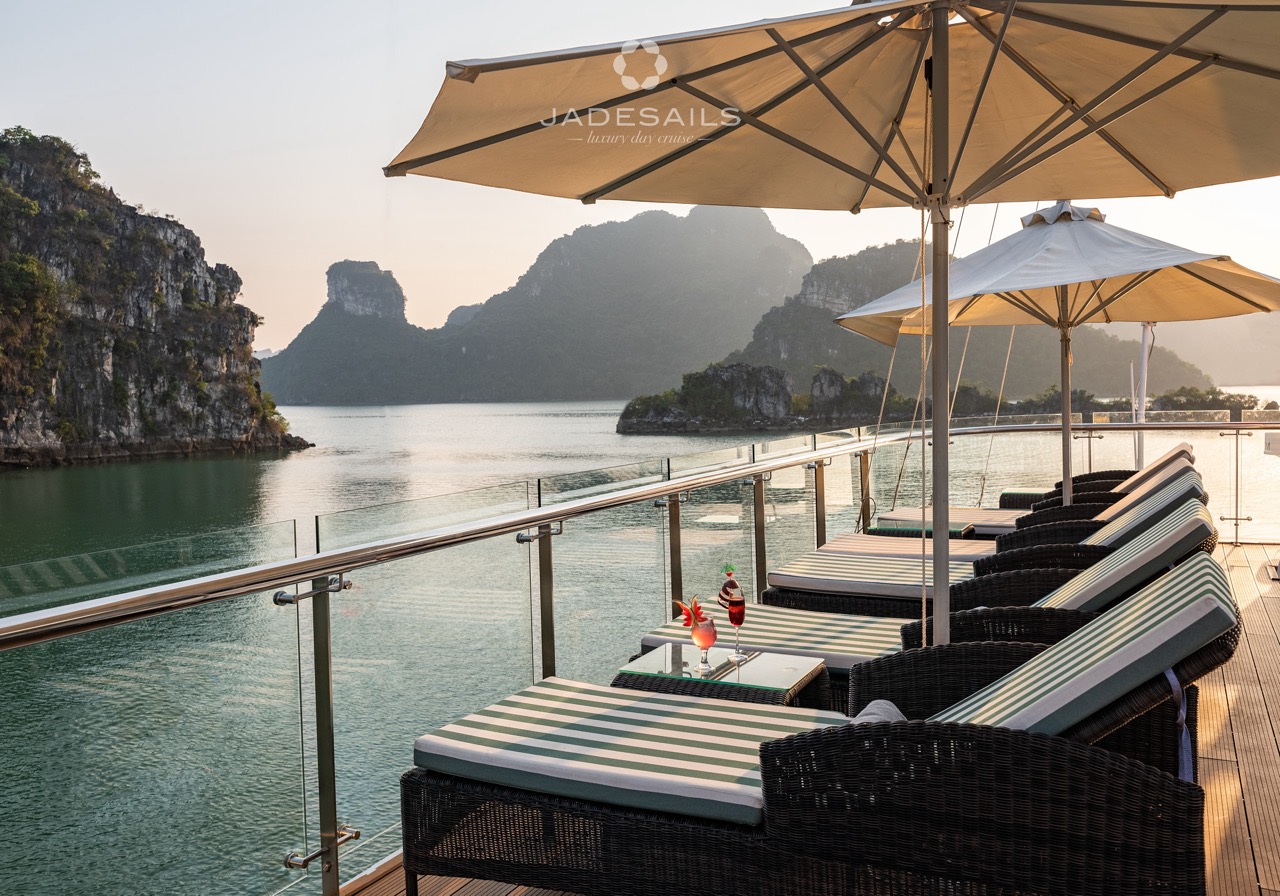 Stunning Halong Bay cruise balcony with scenic limestone karsts and tranquil waters at sunset.
