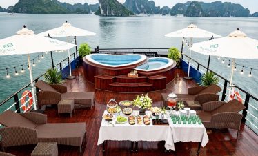 Luxury cruise balcony overlooking Halong Bay with hot tub and scenic views.