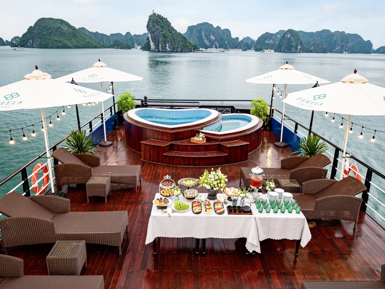 Luxury cruise balcony overlooking Halong Bay with hot tub and scenic views.