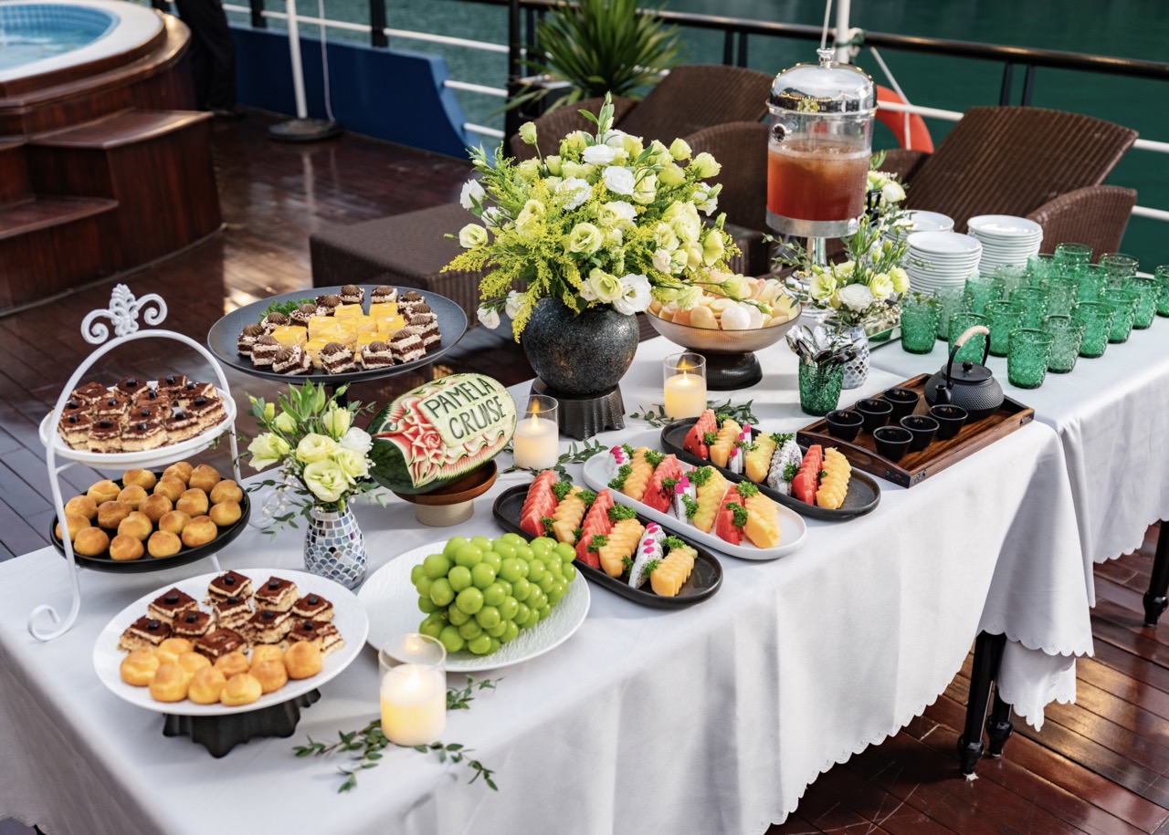 Luxurious Halong Bay cruise balcony with gourmet treats and fresh flowers, perfect for a memorable s.