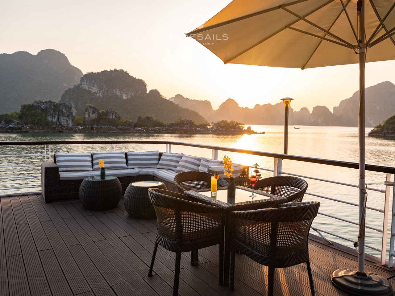 Relaxing cruise balcony with scenic views of Halong Bay at sunset, perfect for a memorable travel ex.
