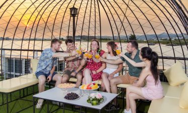 Enjoy a lively sunset celebration on a cruise balcony in Halong Bay with friends.