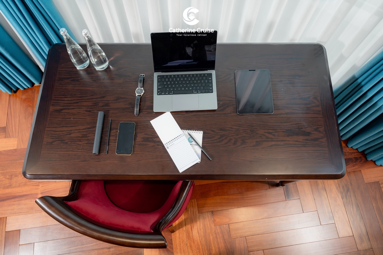 Modern workspace with laptop, smartphone, tablet, watch, and office supplies for professional travel and corporate work.