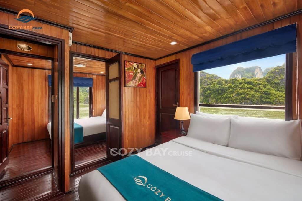 Cozy Bay Cruise cabin with wooden interior and scenic view of Halong Bay.