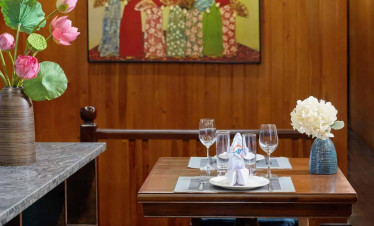 Cozy bay cruise dining experience with elegant table setting and traditional artwork.