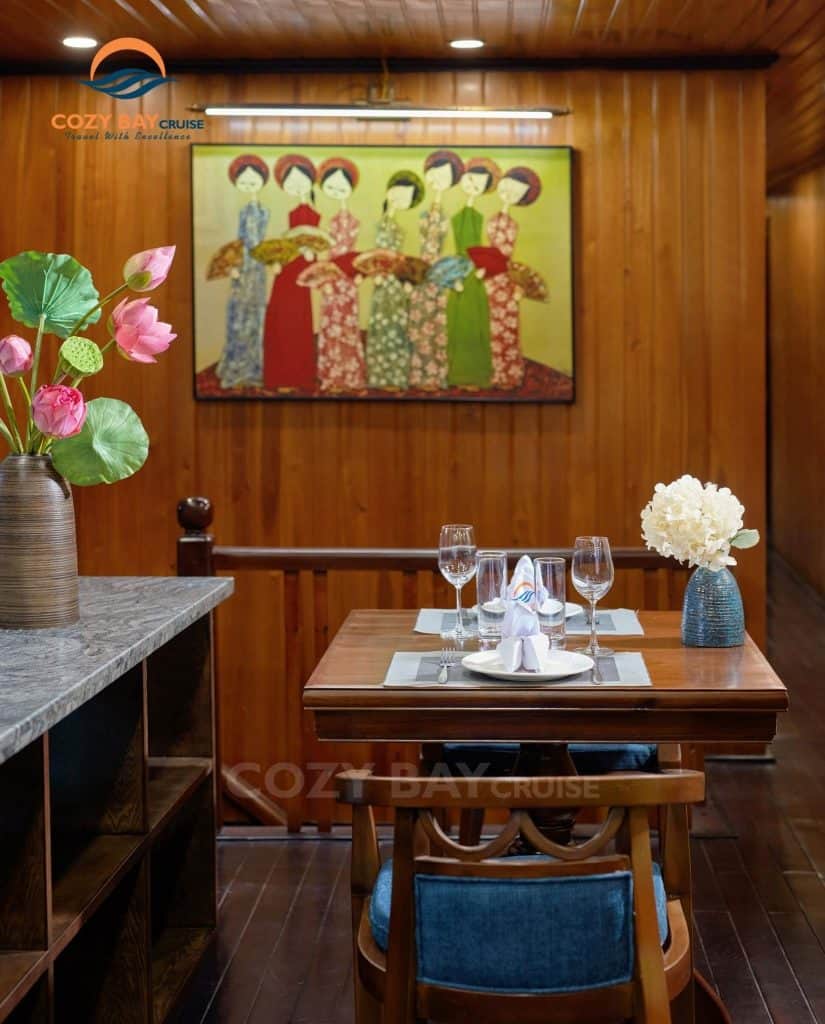Cozy bay cruise dining experience with elegant table setting and traditional artwork.