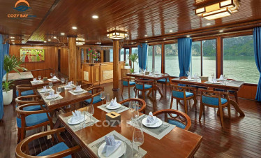 Halong Bay cruise dining area with elegant wooden decor and scenic water views.