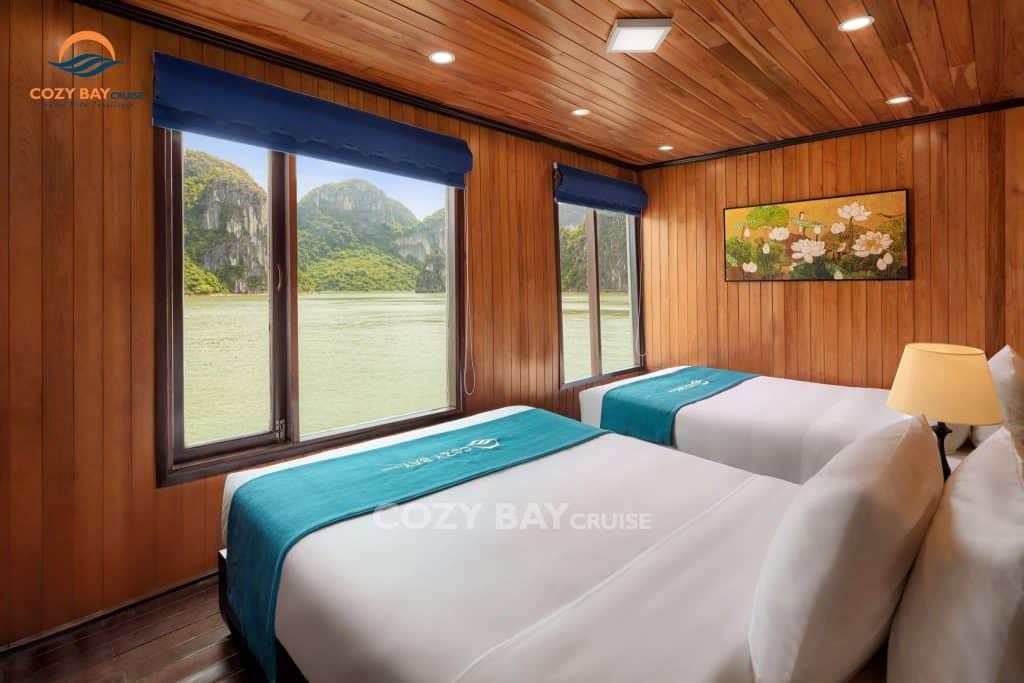 Cozy Bay Cruise interior with scenic views of Halong Bay through large windows, offering a luxurious.