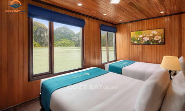 Cozy Bay Cruise interior with scenic views of Halong Bay through large windows, offering a luxurious.