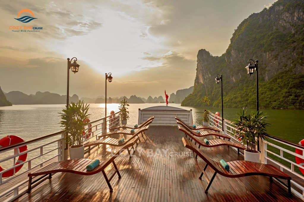Cozy bay cruise deck with scenic view of limestone karsts at sunset, relaxing and luxurious experien.