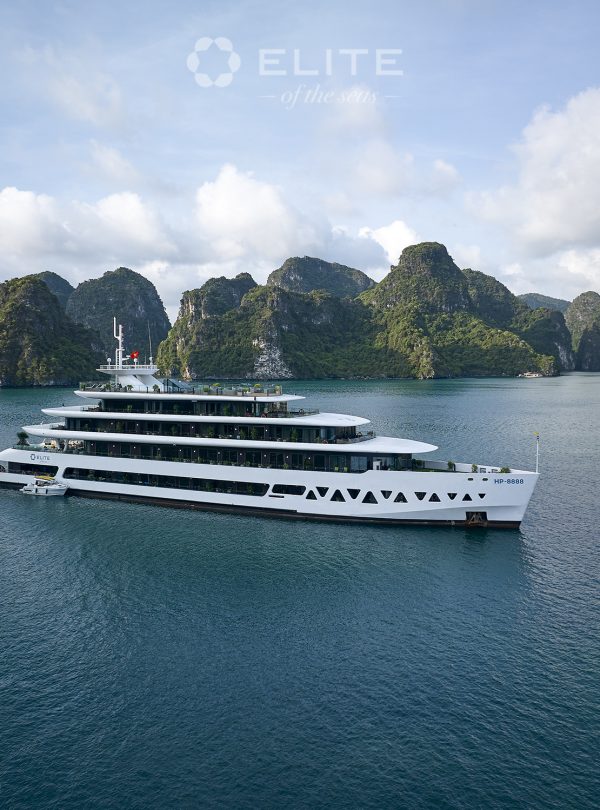 Luxury cruise ship exploring Halong Bay with limestone karsts and emerald waters.