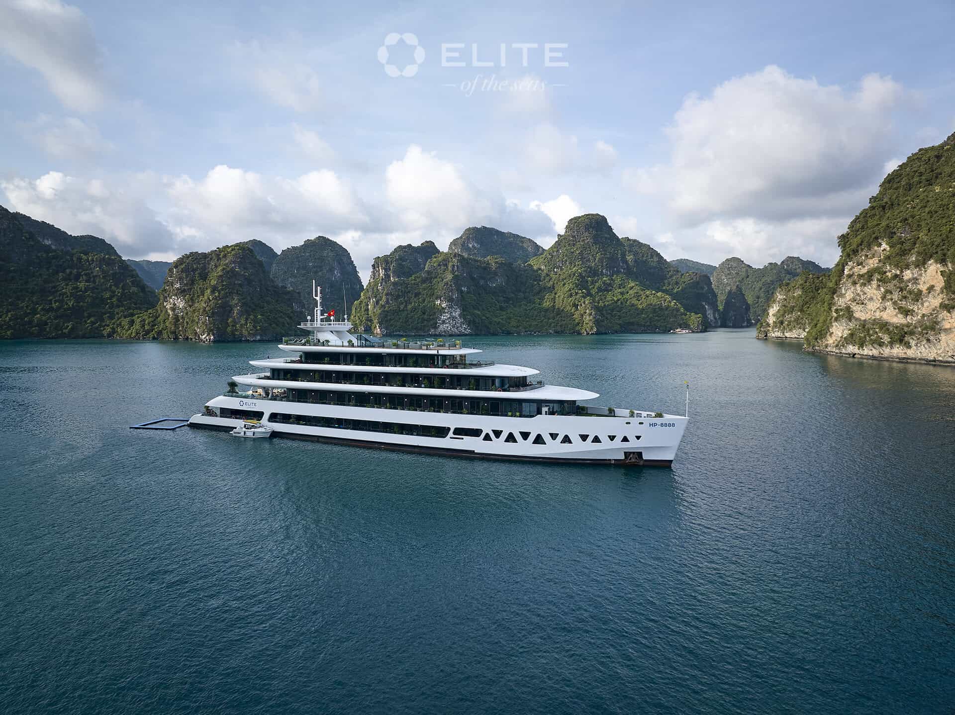 Luxury cruise ship exploring Halong Bay with limestone karsts and emerald waters.