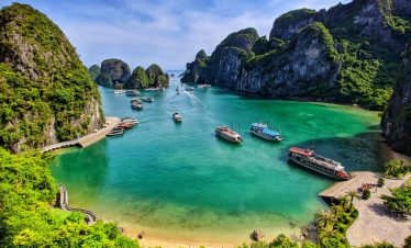Halong Bay cruise ships and emerald waters surrounded by limestone karsts.