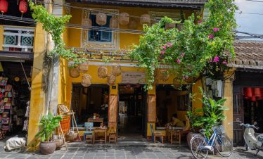 Hoi An Heritage Town street scene with traditional architecture and vibrant greenery.
