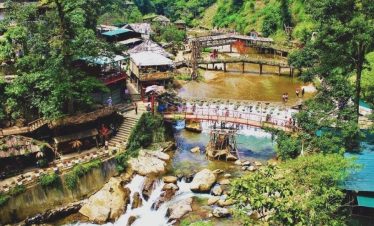 Hanoi Sapa scenic river view with lush greenery and traditional village houses.